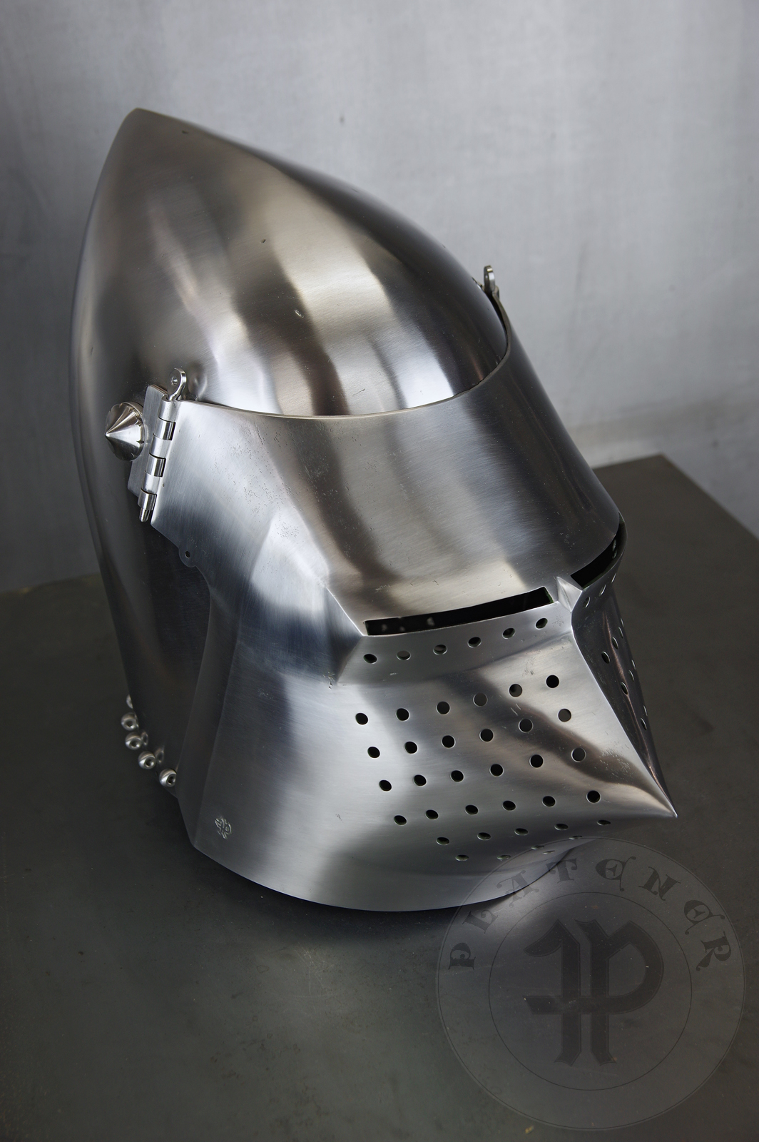 Visored bascinet based on example from Le Landeron in Switzerland, circa 1380-1400. Material: 2 mm steel with 0,3 % carbon. Heat treatment: hardened and tempered up to 34 HRC. Weight 4,090 kg / Przybica starszego typu tzw. psi pysk wzorowana na oryginale z Le Landeron w Szwajcarii, datowana na 1380-1400 rok. Materia: stal 2 mm o zawartoci wgla 0,3%. Hartowany i odpuszczany do 34 HRC. Waga 4,090 kg.